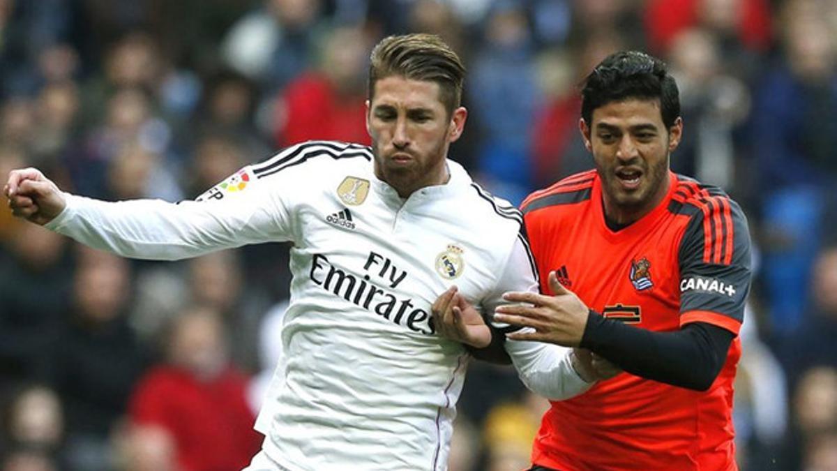 Carlos Vela luchando un balón con Sergio Ramos