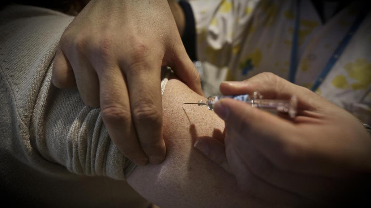 Una enfermera administra una vacuna de la gripe.