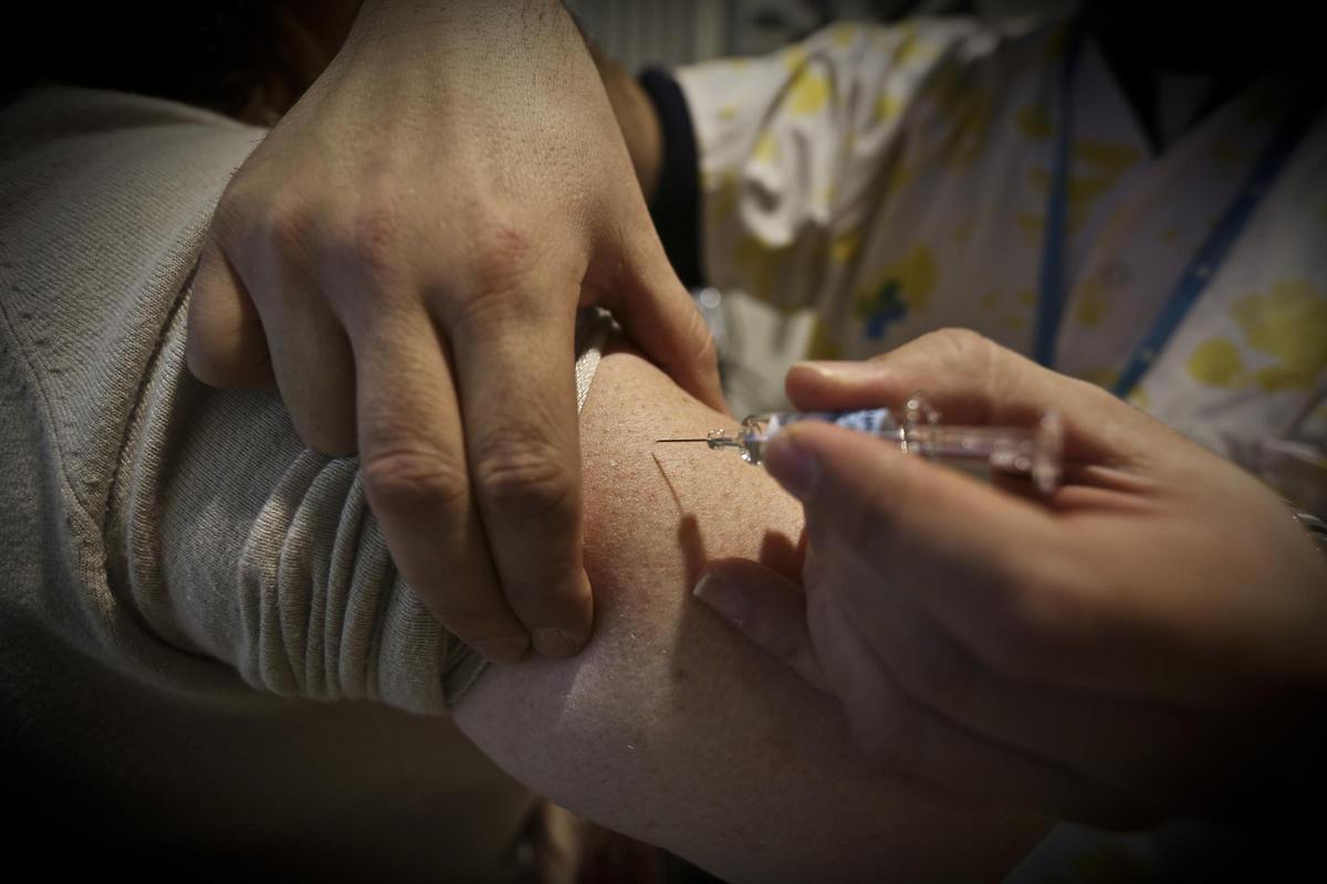 Una enfermera administra una vacuna de la gripe.