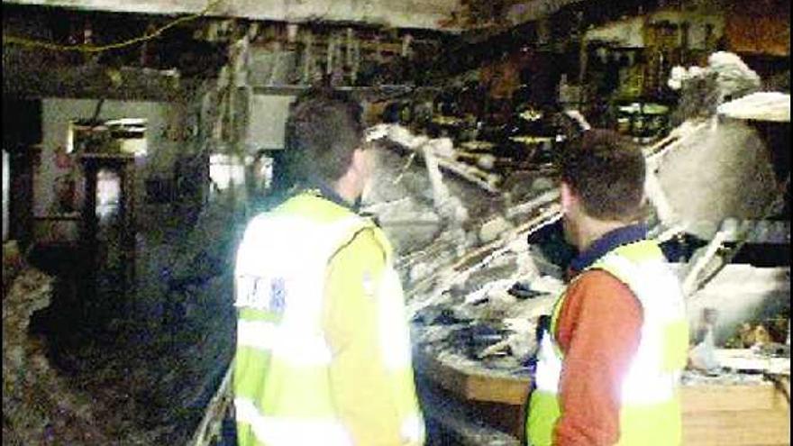 Bomberos, en el bar El Principado de Madrid, con parte del techo derrumbado.