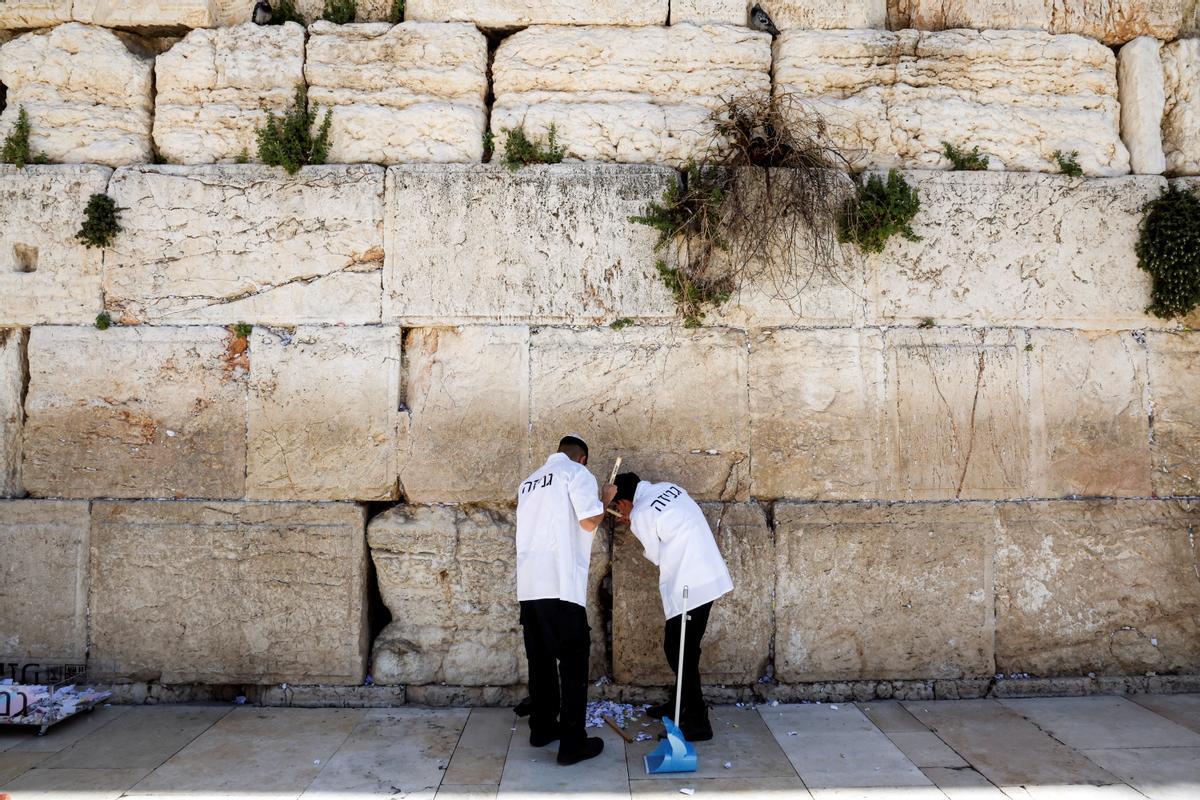 Trabajadores retiran notas de las grietas del Muro de los Lamentos para dejar espacio, como parte de los preparativos previos a la festividad judía de la Pascua, en la Ciudad Vieja de Jerusalén.