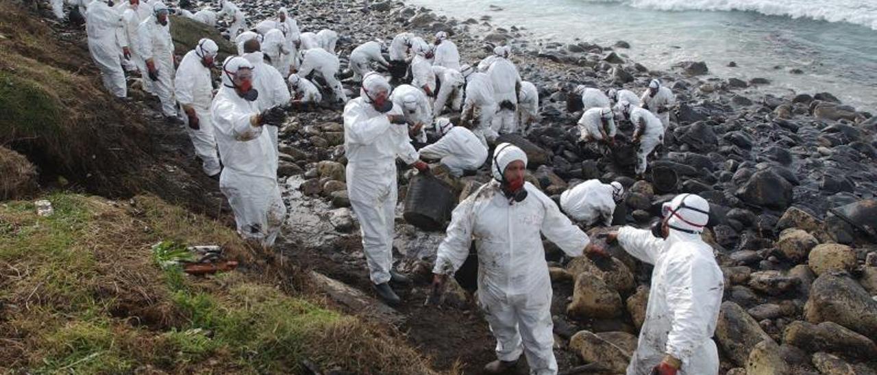 Voluntarios recogiendo el fuel que llegó a la costa gallega procedente del “Prestige”