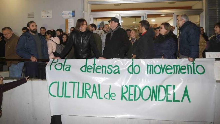 Representantes de los colectivos integrados en la plataforma cultural &quot;Sinha Paca&quot; de Redondela, ayer, durante la protesta a las puertas del multiusos momentos antes del inicio del pleno. // Ricardo Grobas