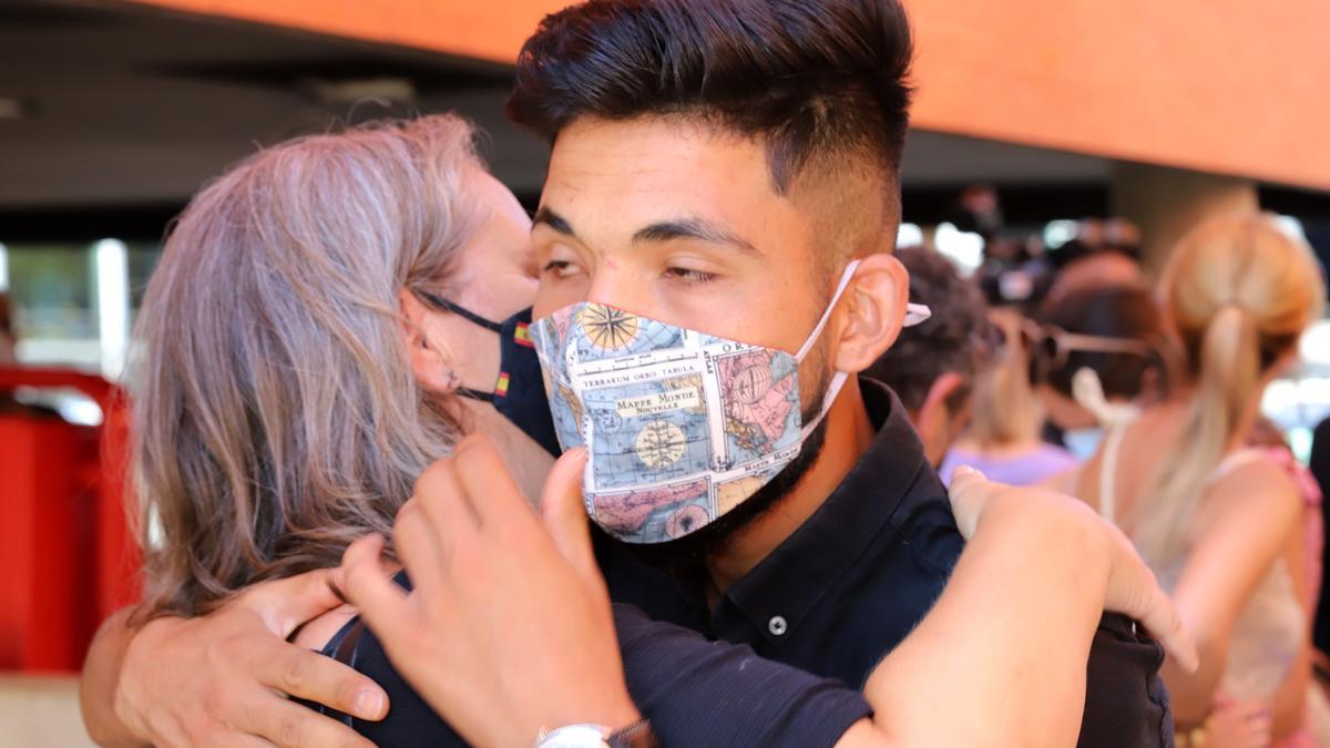 Uno de los chicos, ya exonerados, recibe un abrazo de una allegada, hoy en la rueda de prensa.