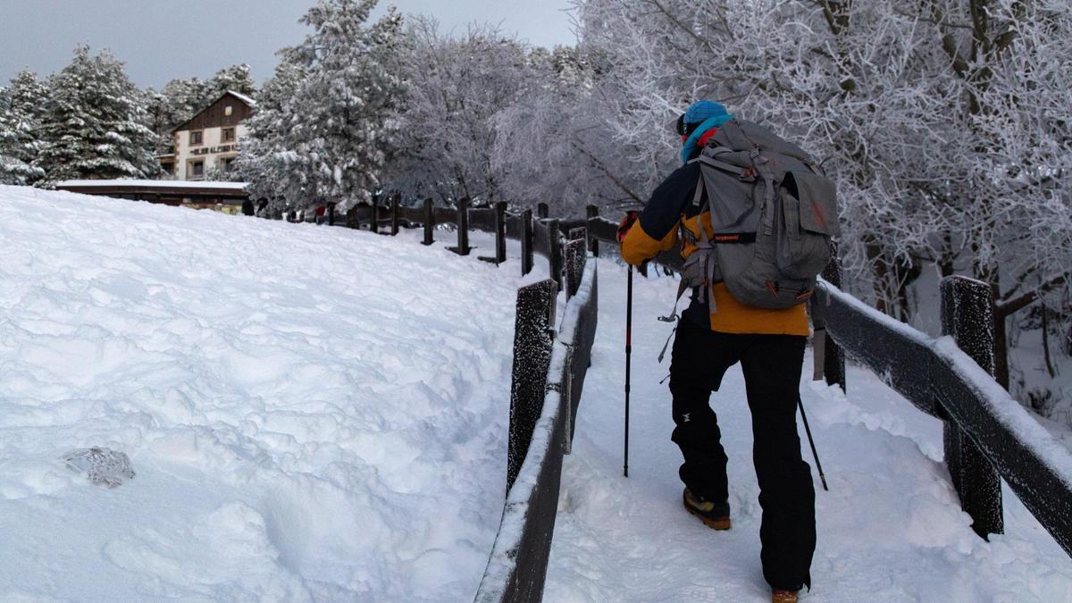 Una persona hace senderismo en un camino cubierto por la nieve