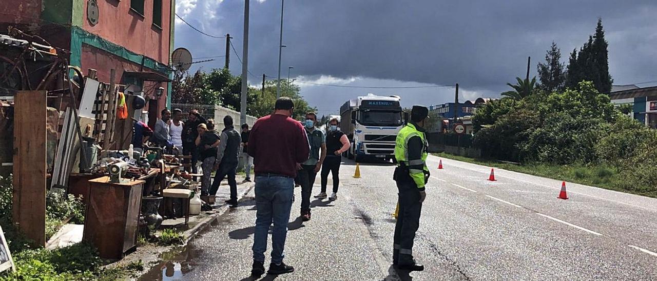 Agentes de la Guardia Civil de Tráfico, en la recta de Coruño, investigan el atropello, con la familia del joven fallecido –a la izquierda– recibiendo condolencias por la pérdida.