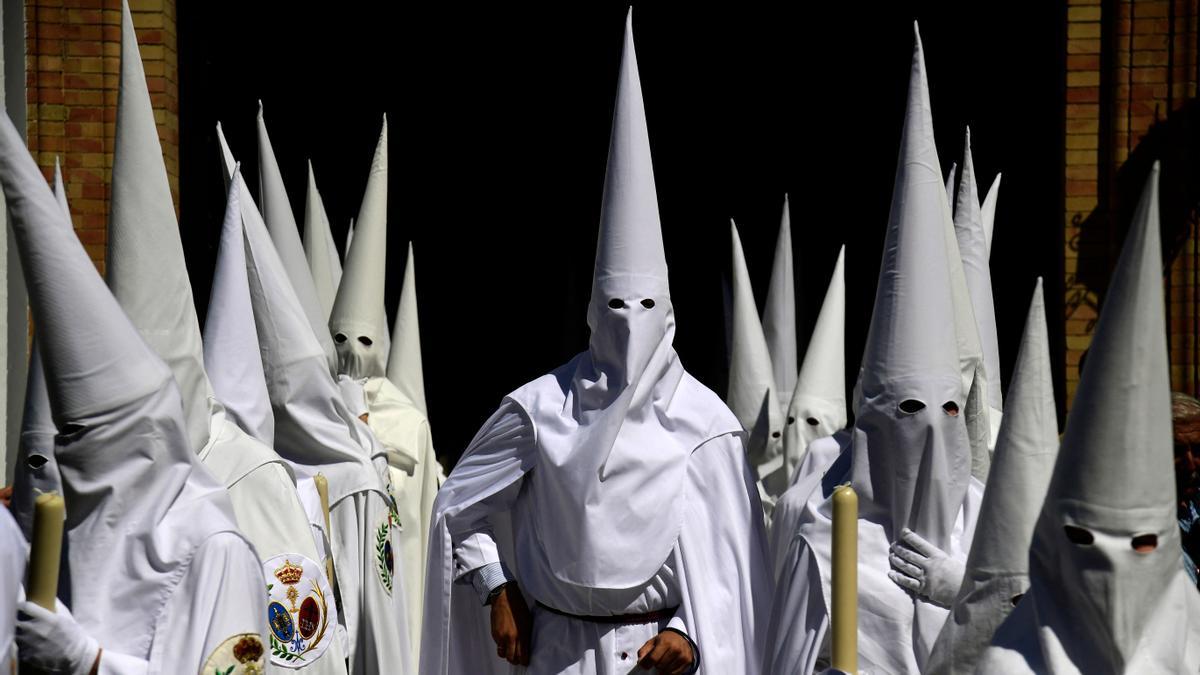 Penitentes de la hermandad de La Paz participan en la procesión del Domingo de Ramos en Sevilla