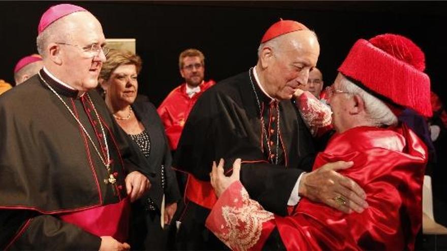 El cardenal García-Gasco abraza al purpurado Antonio Cañizares, con el birrete de honoris causa, ante Osoro y la presidenta de las Corts, ayer.