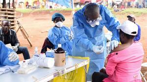 Un sanitario administra la vacuna contra el ébola a una mujer que tuvo contacto con un enfermo.