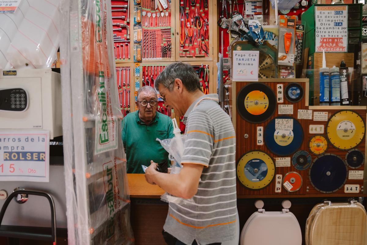 Primitivo atiende a un cliente en su ferretería de Madrid.