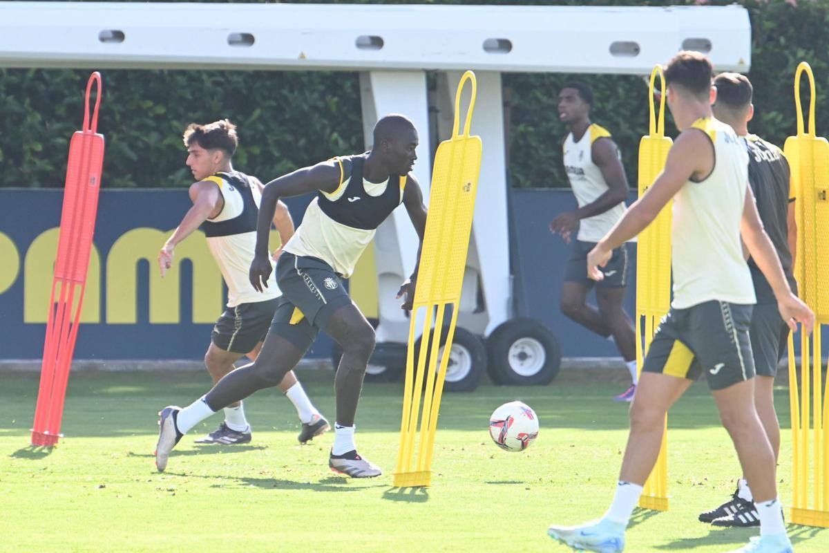 Ramón Terrats (i) y Pape Gueye (c), con balón, en el entrenamiento de ayer ante la mirada del preparador físicos del Villarreal, Ismael Fernández.