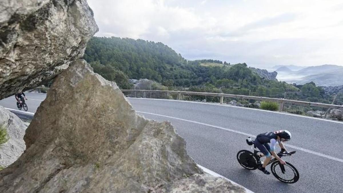Un hombre va con una bici por el norte de Mallorca.