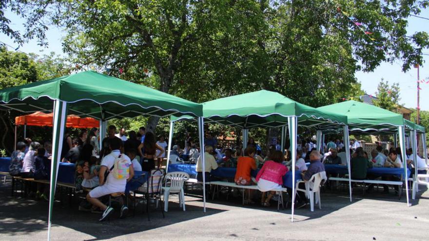 Los vecinos comparten una comida por la celebración. | A. Saavedra