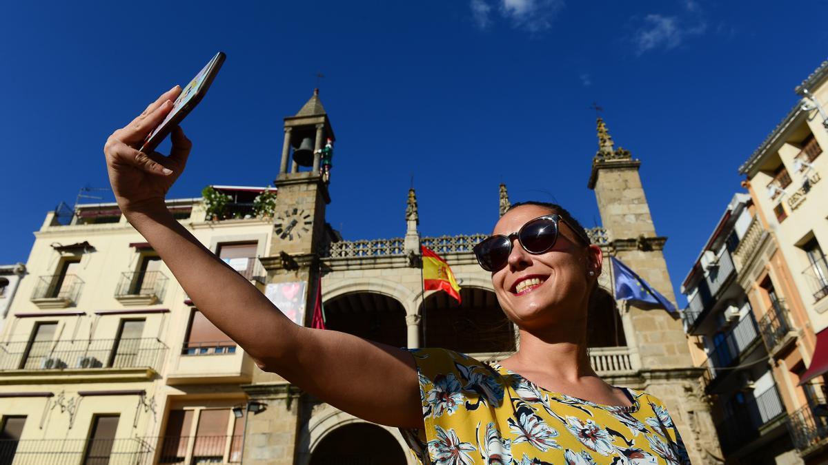 Una mujer se hace un &#039;selfie&#039;, sonriente, ante el Abuelo Mayorga de Plasencia.