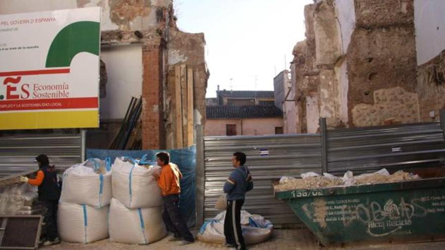 Operarios trabajando en la reconstrucción del tramo de muralla que fue derribado en la calle Dolors.