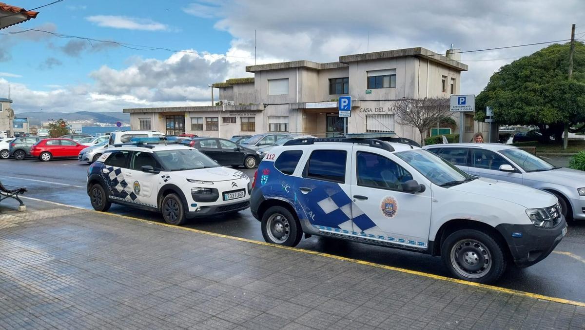 Los dos vehículos de la Policía Local de Bueu, con la sede al fondo.