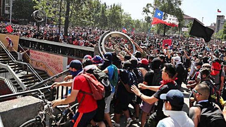 Manifestants llancen bicicletes a un accés del metro.