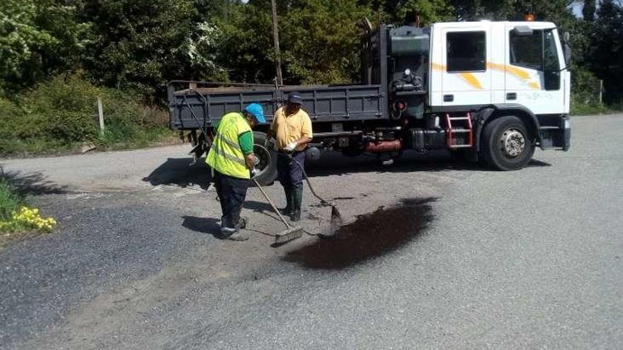 Dos operarios bachean uno de los viales del municipio. // FdV