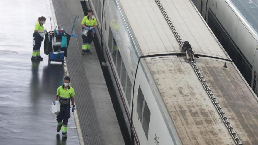 Varios trabajadores caminan por un andén en la estación de Atocha.