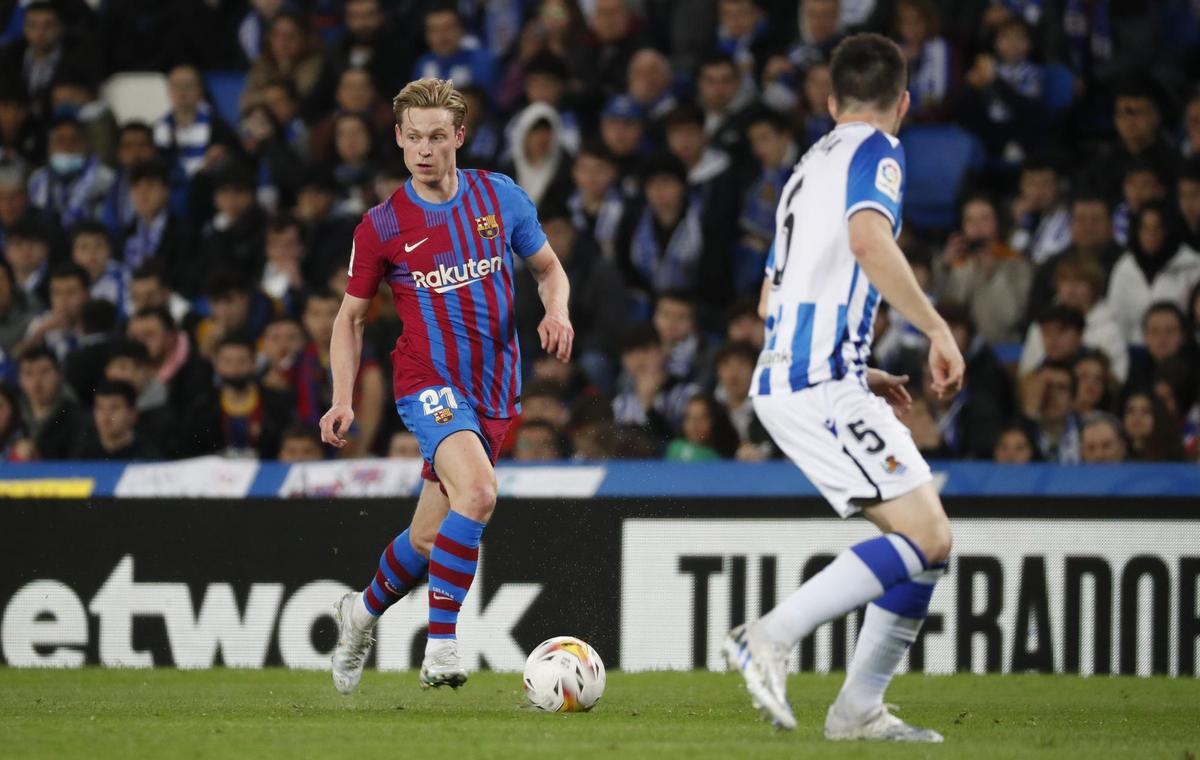 SAN SEBASTIÁN, 21/04/2022.- El centrocampista neerlandés del FC Barcelona, Frenkie de Jong (i), conduce el balón ante el centrocampista de la Real Sociedad, Igor Zubeldia, durante el encuentro correspondiente a la jornada 33 disputado hoy jueves en el Reale Arena de San Sebastián. EFE / Juan Herrero.