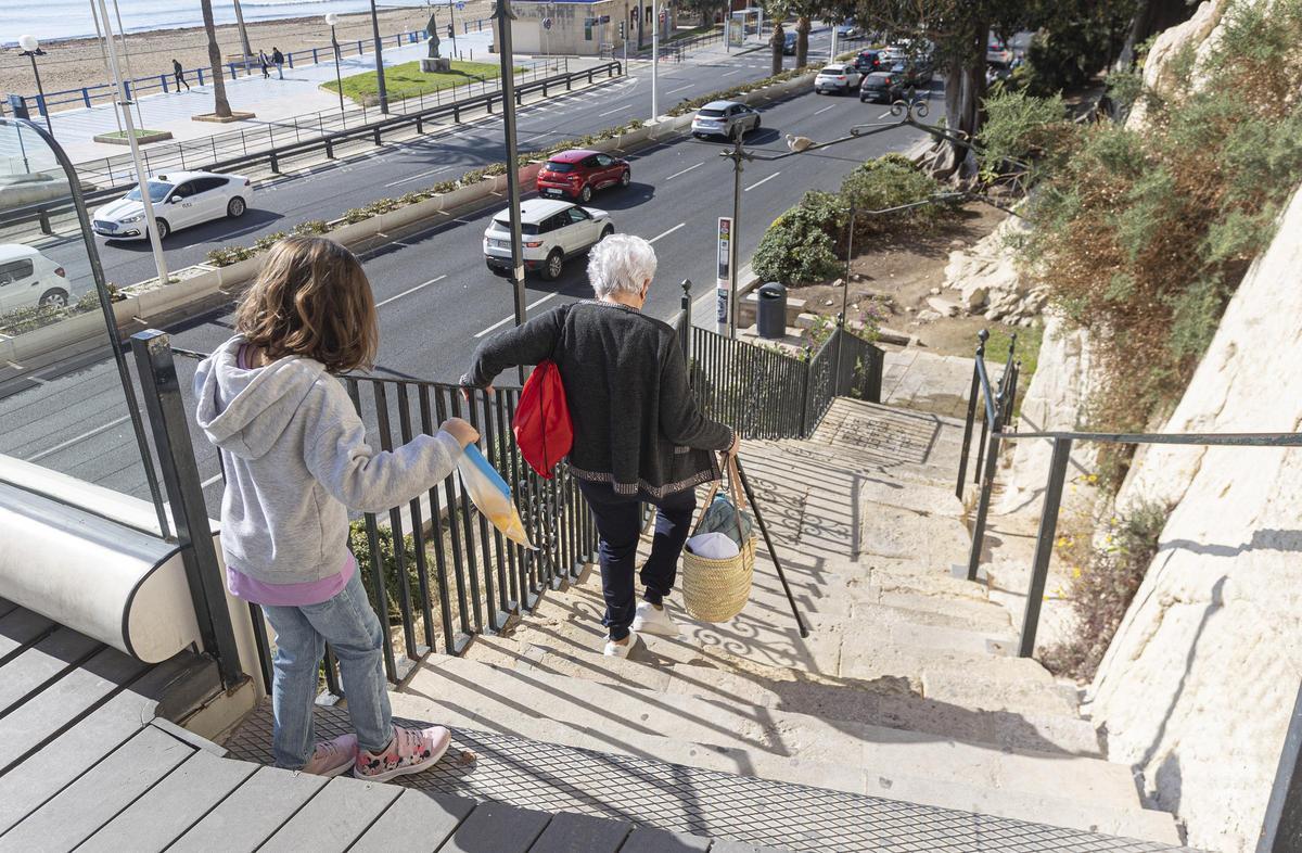 Una mujer con bastón baja por las escaleras al estar el ascensor estropeado, este jueves.