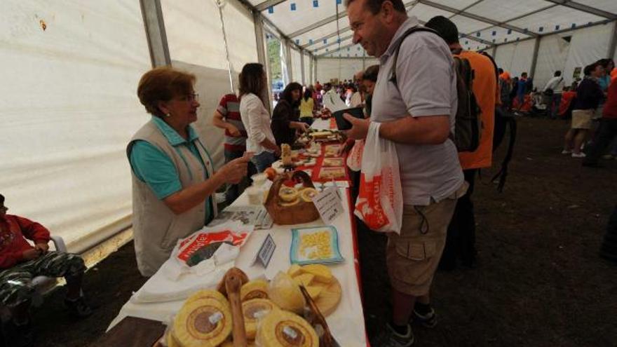 Un cliente adquiere un queso a Marigel Álvarez, una de las productoras.