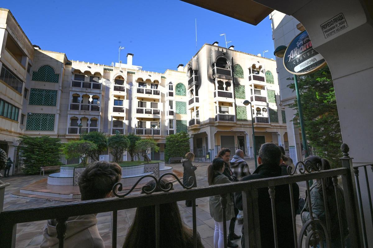 Vecinos frente al edificio incendiado en Crevillent la mañana después del suceso