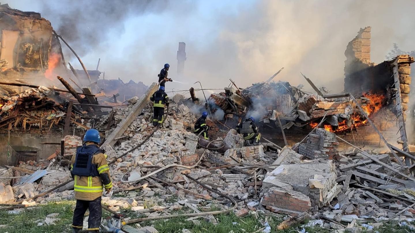 Emergency crew tend to a fire near a burning debris, after a school building was hit as a result of shelling, in the village of Bilohorivka, Luhansk, Ukraine, May 8, 2022. State Emergency Services/Handout via REUTERS