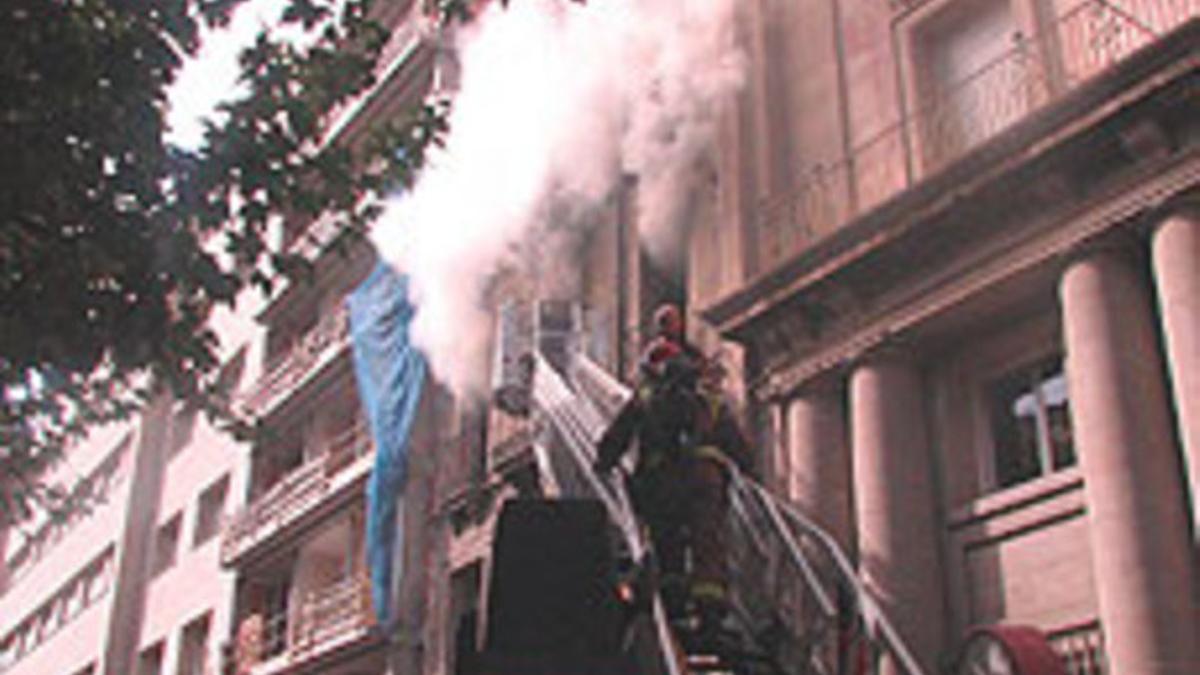 Los bomberos acceden al piso incendiado en LLeida con una escalera.