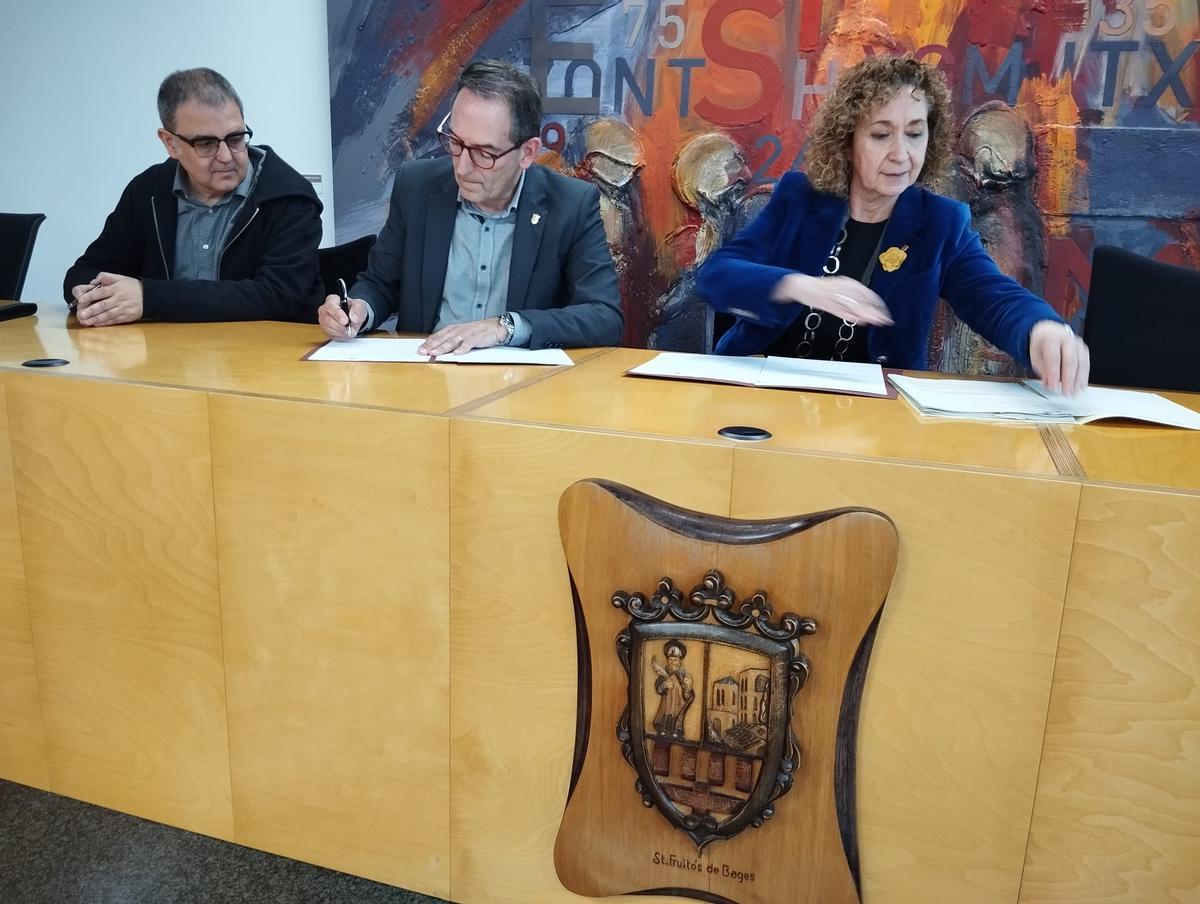 Joan Carles Batanés (al centre) i Ester Capella, signant el conveni de col·laboració