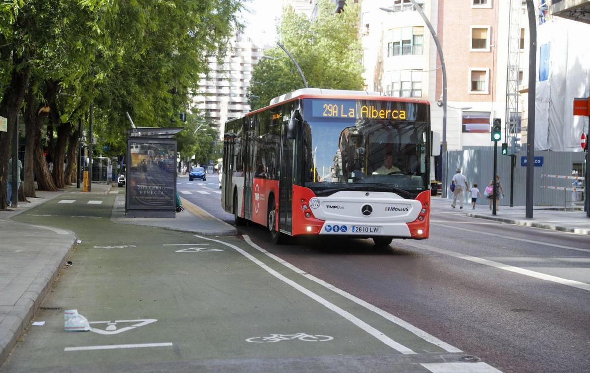 Un autobús y una ciclista, circulando por las nuevas zonas destinadas al transporte público y a los vehículos de movilidad personal del plan de movilidad | FRANCISCO PEÑARANDA