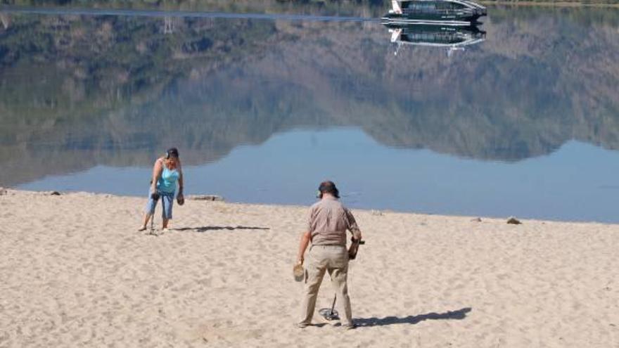 Un grupo de turistas que ayer eligieron el Lago de Sanabria para disfrutar con la visión de sus claras aguas y del paisaje del Parque Natural.