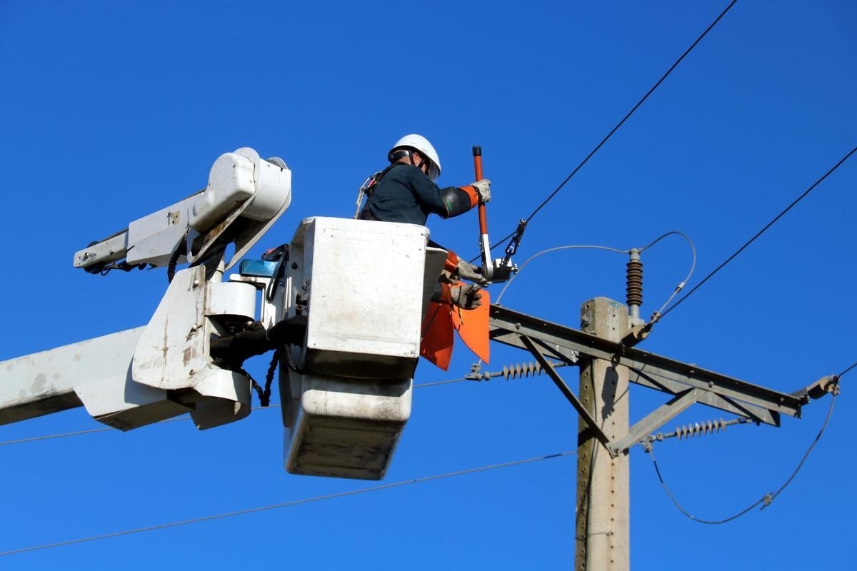 Obreros trabajan para mejorar una torre eléctrica de Endesa.