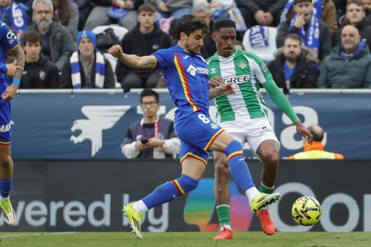 El delantero dominicano del Betis Júnior Firpo (d) pelea un balón con el centrocampista uruguayo del Getafe Mauro Arambarri.