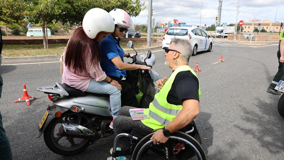 Carlos Fernández alerta a dos mujeres en moto del peligro de las distracciones en la carretera, este martes en Son Hugo.