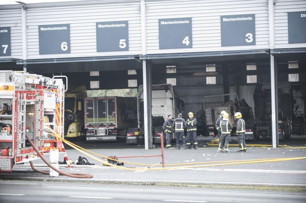 Bomberos del parque comarcal y efectivos de emergencias de Oleiros apagan un fuego en una nave de la compañía MAN situada junto a la Nacional VI - El fuego calcinó un camión y afectó a otros dos.