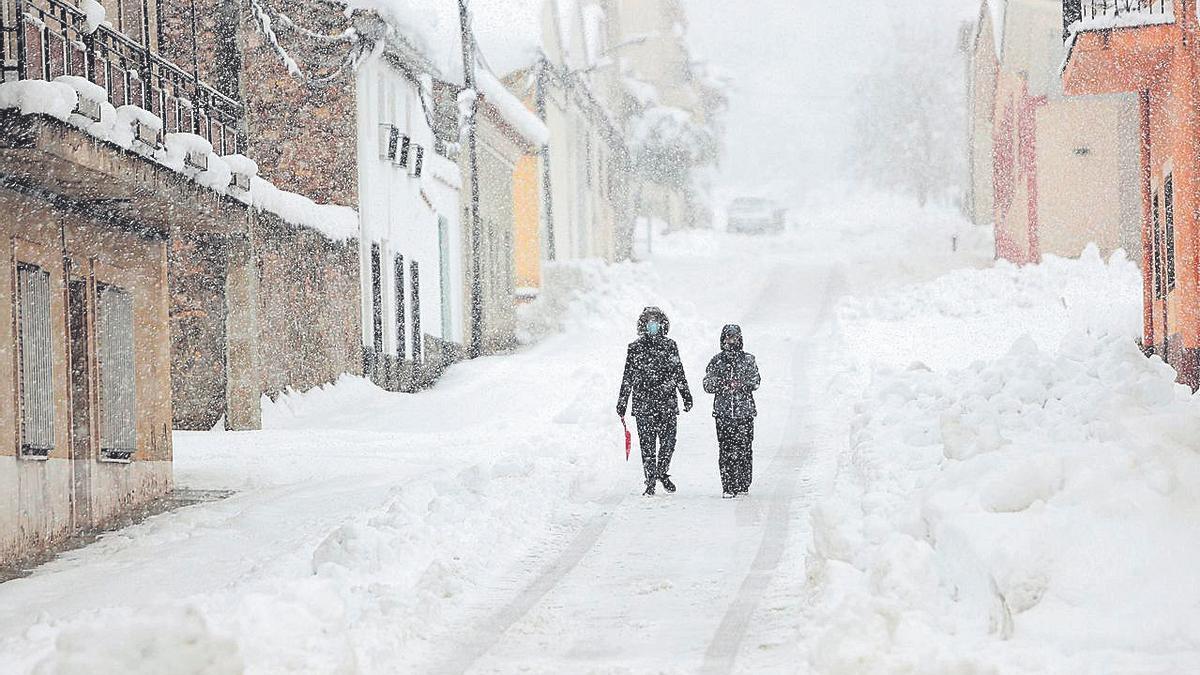 Dos vecinos, en plena nevada por las calles de Sinarcas. F. Calabuig