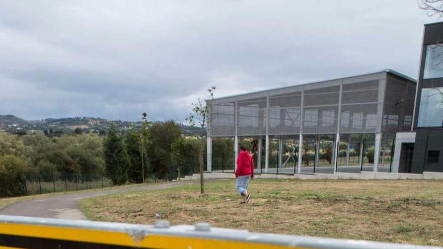 Cartel que advierte del corte de la senda, con el polideportivo del colegio Carmen Ruiz-Tilve al fondo.