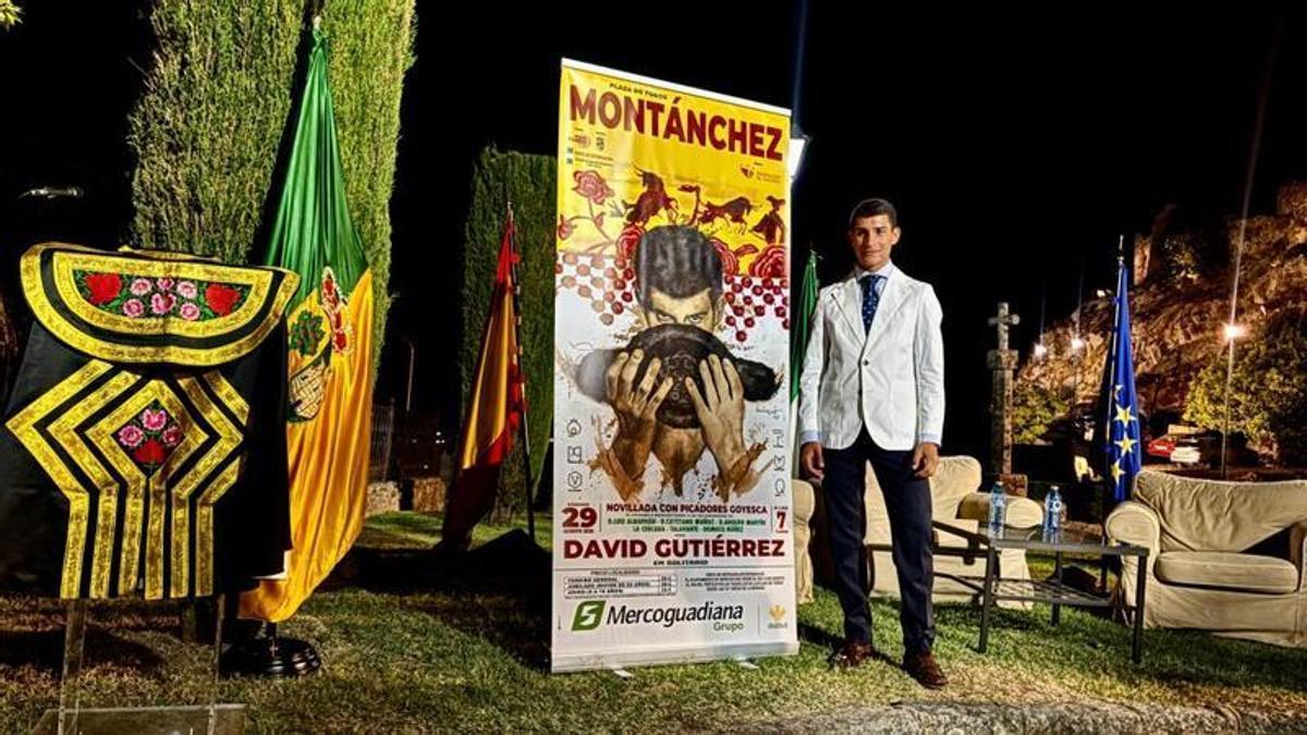 David Gutiérrez, junto al cartel de su encerrona en Montánchez, obra del artista Pérez Indiano.