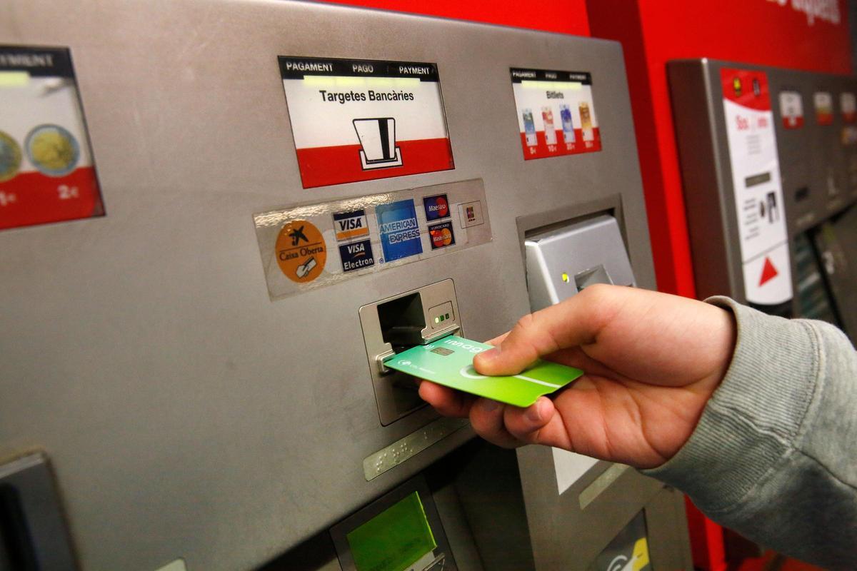 Recarga de ua T-mobilitat en una máquina de venta de billetes de metro, en la estación del Clot