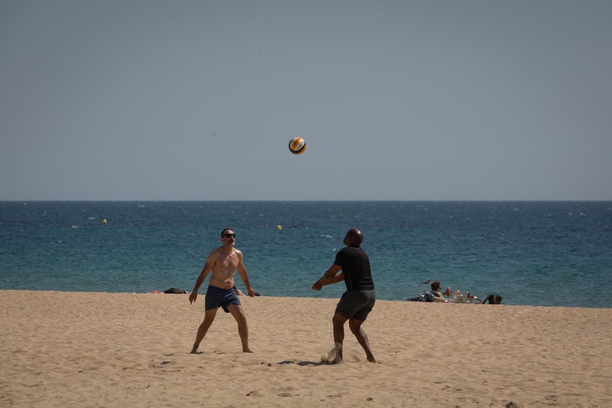 Dos hombres juegan al voleibol en la playa del Bogotell el día de la presentación del protocolo para el control del aforo de playas.