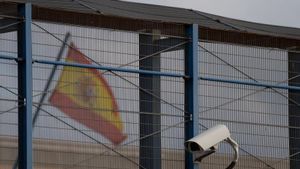 Verja, bandera y cámara de vigilancia en el Centro de Internamiento de Extranjeros de la Zona Franca de Barcelona.