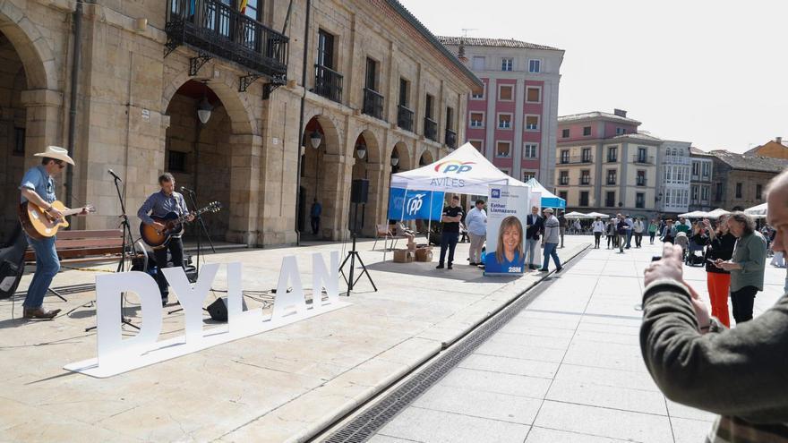 Eduardo Herrero y Jorge Otero, ayer, en la plaza de España; al fondo, los puestos electorales del PP y de Foro. | Mara Villamuza