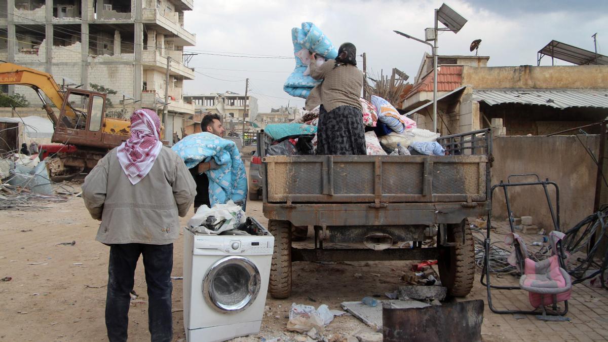 Residentes de la devastada ciudad siria de Jindyris intentan salvar algunas pertenencias entre los escombros 
