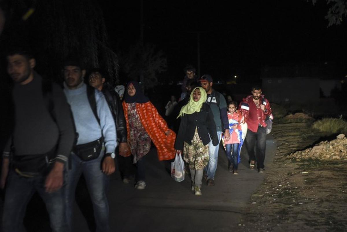 Un grupo de inmigrantes camina en medio de la noche en los alrededores de la localidad serbia de Miratovac.