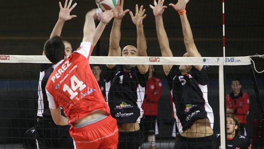 El triple bloqueo del Palma Volley intenta parar el remate de Ibán Pérez.