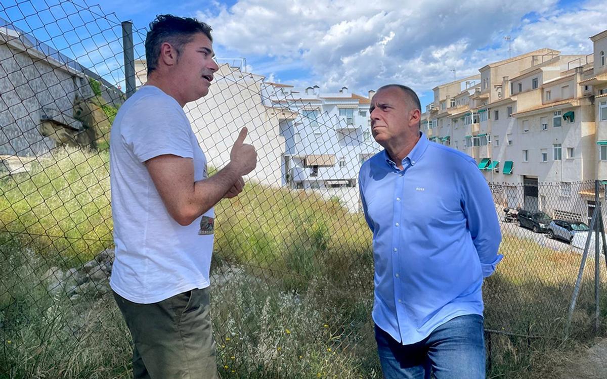 El concejal de Urbanismo de Altea (izda) y el alcalde conversan junto a la parcela pública para construir viviendas sociales.