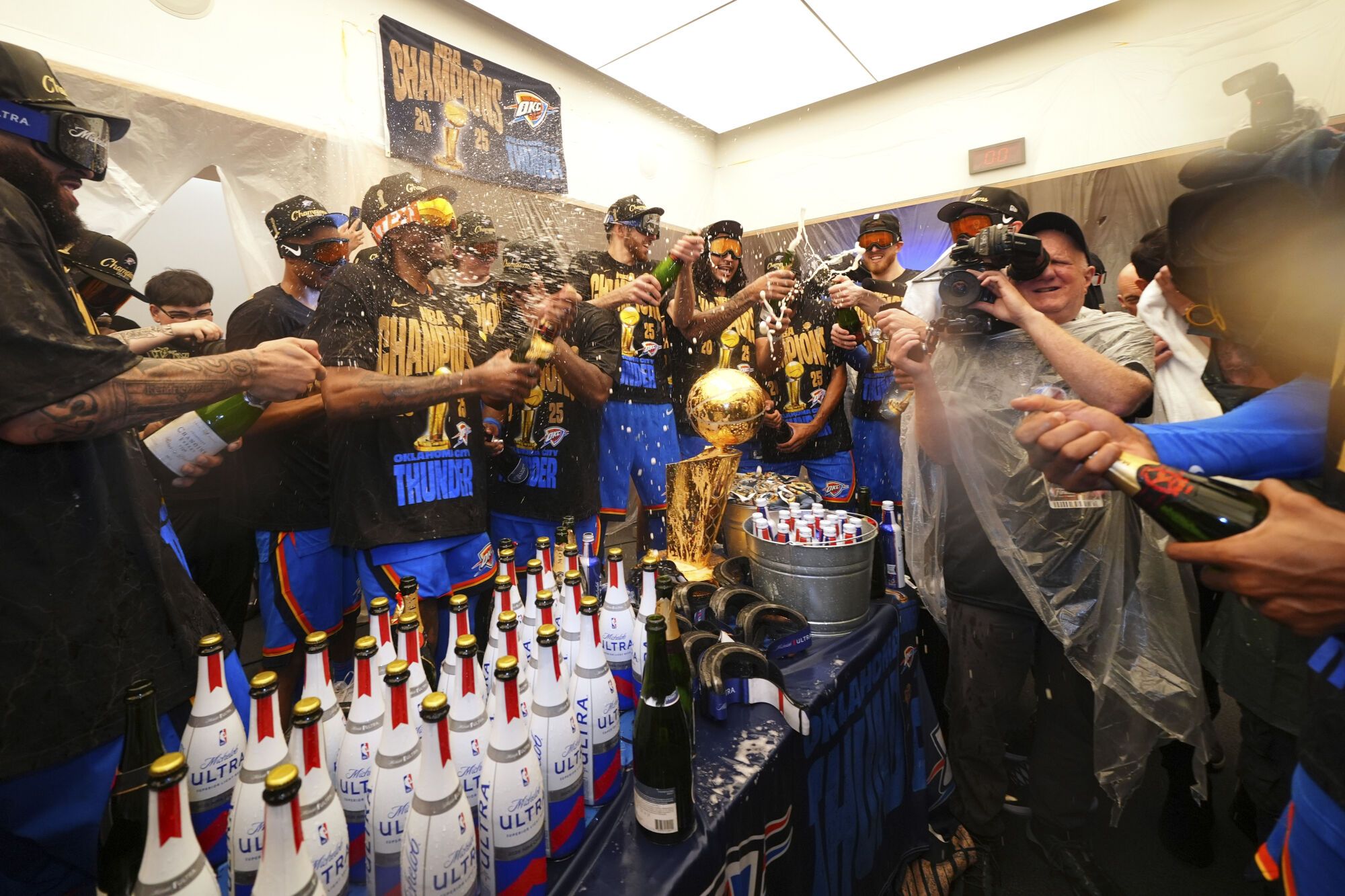 Oklahoma City Thunder players celebrate in the locker room after winning the NBA basketball championship with a Game 7 victory against the Indiana Pacers Sunday, June 22, 2025, in Oklahoma City. (AP Photo/Julio Cortez)
