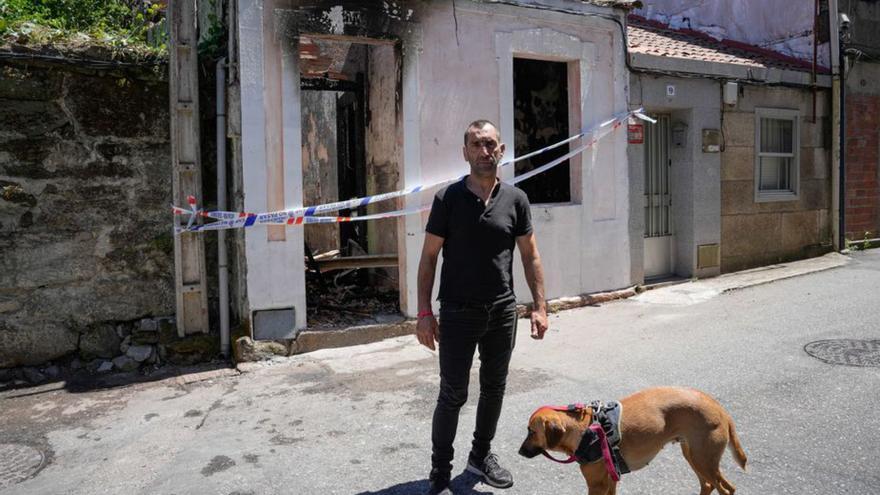 El hombre que residía en la vivienda que ardió en la  calle Simancas, con su perro ante la casa precintada.   | // A. IRAGO