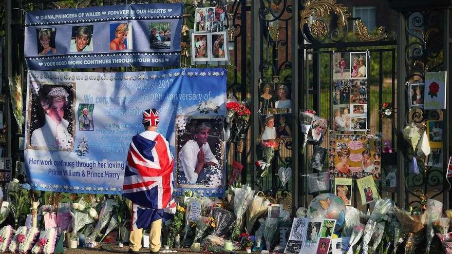 Un admirador mira las flores en memoria de la difunta princesa Diana, a las puertas del palacio de Kensington.